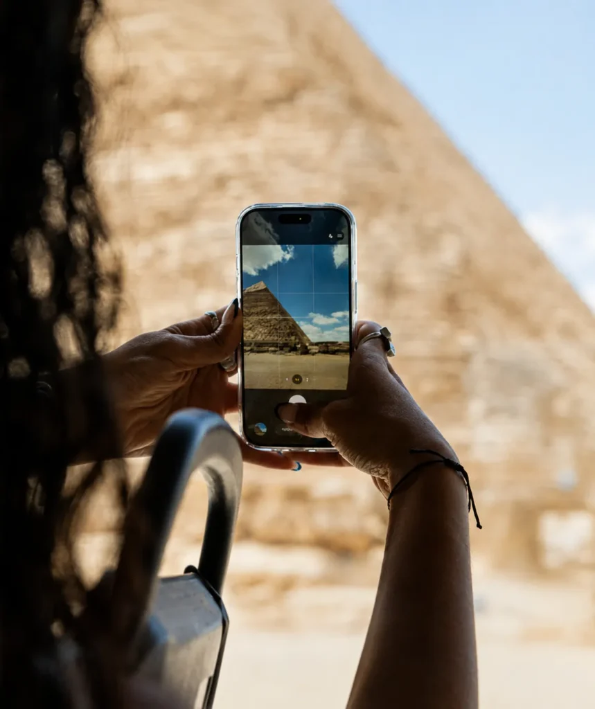 Traveler photographing the Great Pyramid of Giza with a smartphone