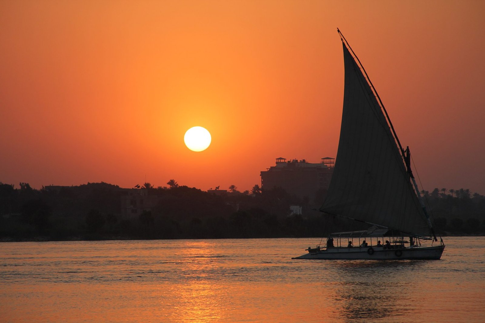 The sunsets in cairo and the sail boat is alone in the area. Only acompanied by the beautiful colors of the sky and water.