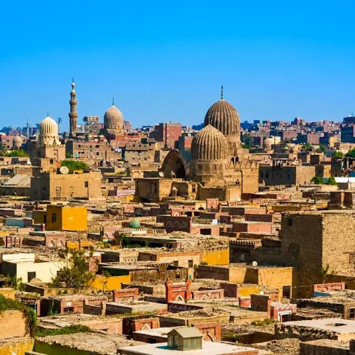 Panoramic view of Cairo’s Northern Cemetery with twin ribbed Mamluk domes and minarets under a clear blue sky