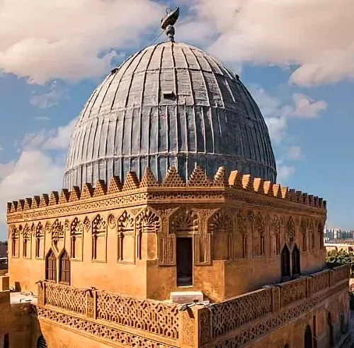 Ribbed stone dome of a Mamluk funerary complex in Cairo’s City of the Dead under a blue sky