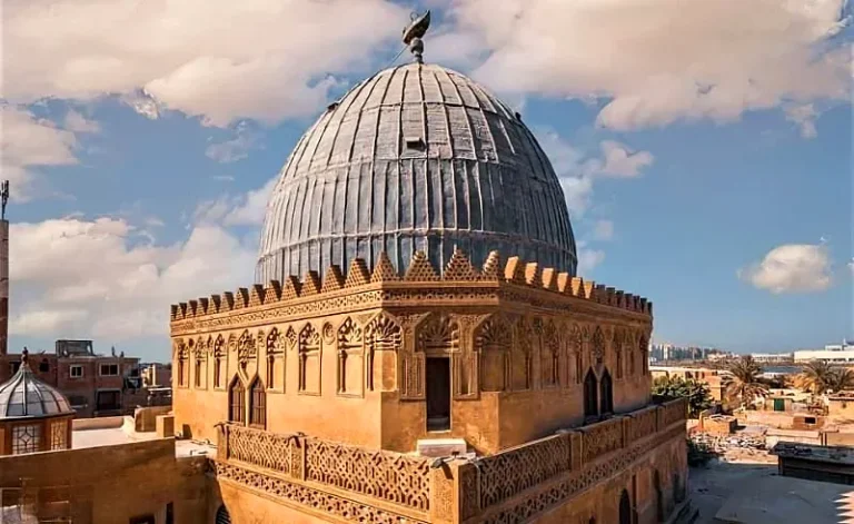 Ribbed stone dome of a Mamluk funerary complex in Cairo’s City of the Dead under a blue sky