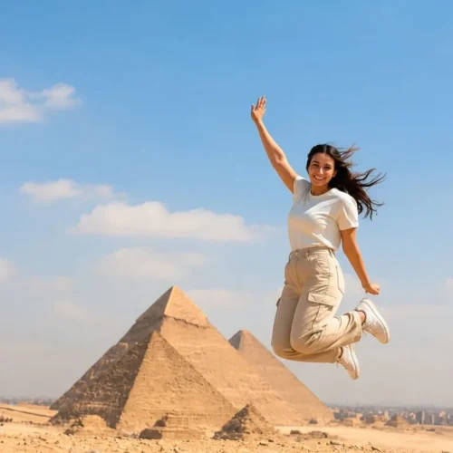 Traveler jumping with joy in front of the Great Pyramid of Giza under a clear blue sky