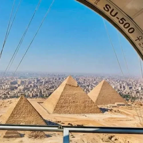View from a tethered-balloon gondola marked SU-500 looking down at the three Giza pyramids