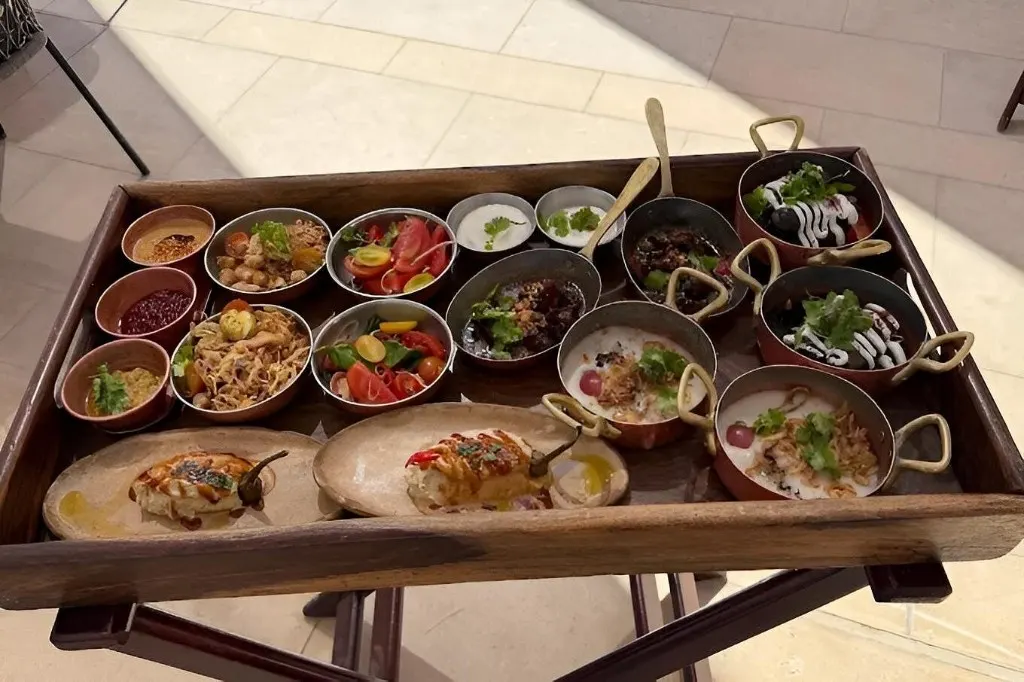 Wooden tray of Egyptian mezze in copper pots and ceramic bowls at Khufu Restaurant