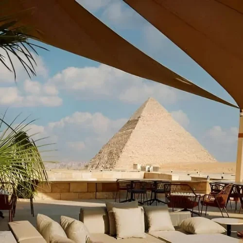 Khufu Restaurant terrace on the Giza Plateau with lounge sofas, dining tables, and a clear view of the Great Pyramid