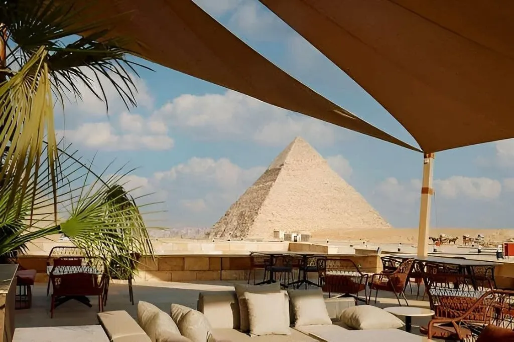 Khufu Restaurant terrace on the Giza Plateau with lounge sofas, dining tables, and a clear view of the Great Pyramid